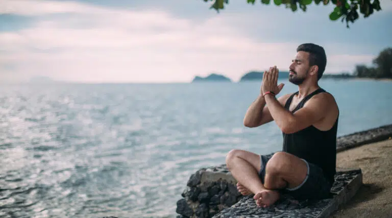 Man practicing Yoga on the waterfront
